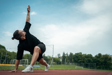 muscle athlete training and doing stretch exercises outdoor
