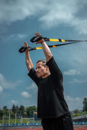 yound sporty athlete or bodybuilder has fitness workout with trx outdoorの写真素材