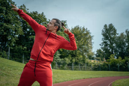 young cheerful personal fitness trainer at running trackの写真素材