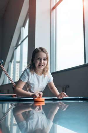 beautiful brunette female playing air hockey with friendの写真素材