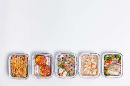 take away lunch boxes with fresh meal in foil container or healthy food deliveryの写真素材