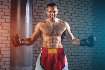 angry muscular sport boxer man with naked torso abs in gymの写真素材