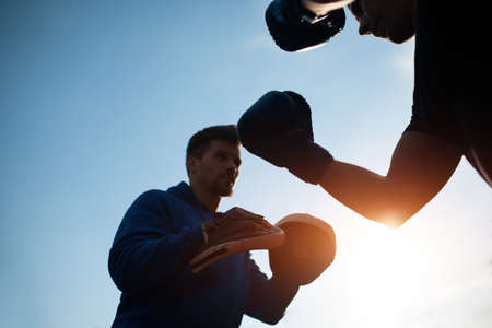 sport man boxing and exercising in boxing gloves with personal fitness trainerの写真素材