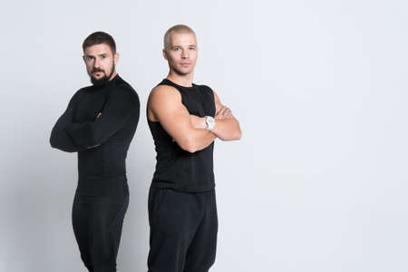 two athletic personal fitness trainers or bodybuilders on white backgroundの写真素材