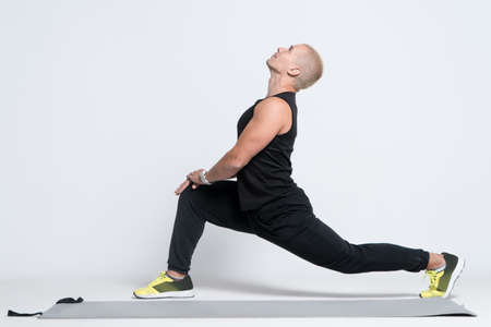 sporty man doing stretching exercise and workout on yoga mat on white backgroundの写真素材