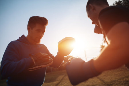 sport man boxer exercising in boxing gloves with personal trainer outdoorの写真素材