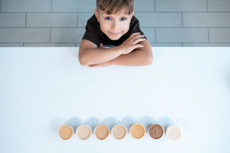 top view of kid and containers with nut or peanut butter on white backgroundの写真素材