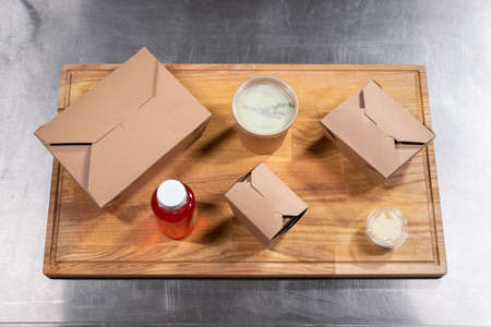 top view of kraft paper food containers with meal for deliveryの写真素材
