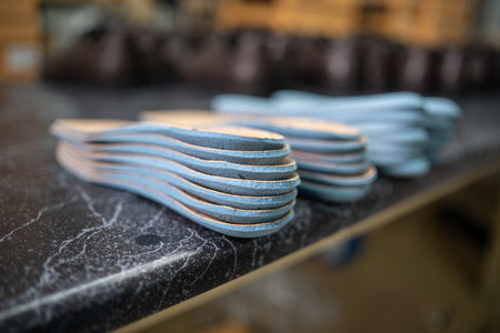 closeup of leather insoles on shelf at footwear manufacture factory