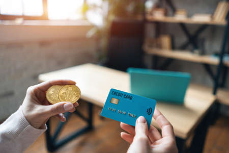 human hand hold and choose credit bank card or golden bitcoin cryptocurrencyの写真素材