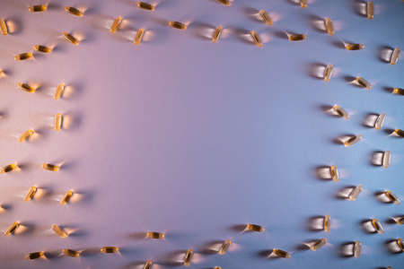 healthy golden fish oil capsules omega 3 vitamins on purple backgroundの写真素材