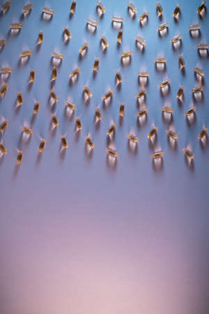 healthy golden fish oil capsules omega 3 vitamins on purple backgroundの写真素材