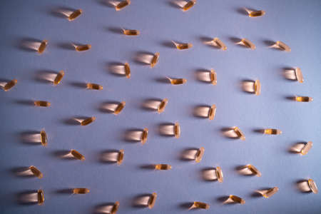 healthy golden fish oil capsules omega 3 vitamins on purple backgroundの写真素材