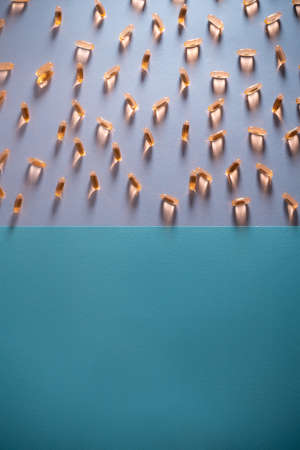 healthy golden fish oil capsules omega 3 vitamins on purple and blue backgroundの写真素材