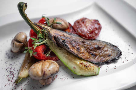 close up of grilled vegetables and champignon on white plate on white backgroundの写真素材