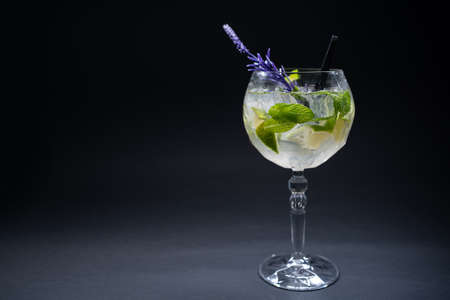 cocktail hugo or mojito with mint, lime and ice in wineglass on black backgroundの写真素材