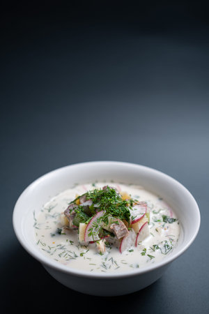 close up of russian traditional cold soup okroshka in bowl on black background