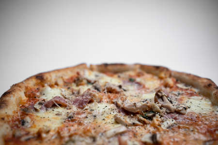 closeup of italian pizza with ham, mushrooms and cheese on white backgroundの写真素材