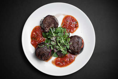 top view of meat beef medallion on tomato and grilled eggplant with salsa sauceの写真素材