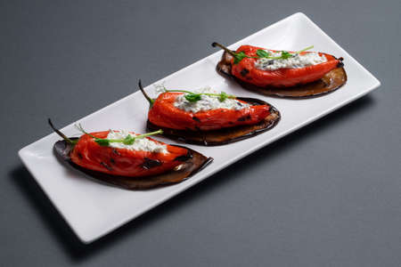 closeup of bulgarian peppers stuffed with cottage cheese on black backgroundの写真素材