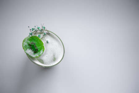fresh green kiwi kick alcohol cocktail drink in wineglass on white backgroundの写真素材