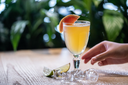 lemonade in glass or refreshing drink with grapefruit, lime and ice on tableの写真素材
