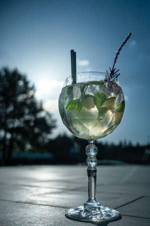 fresh cocktail hugo or mojito with mint, lime and ice cube in wineglass outdoorの写真素材