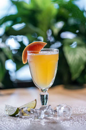 lemonade in glass or refreshing drink with grapefruit, lime and ice on tableの写真素材