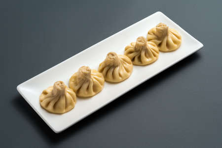 khinkali or georgian dumplings with meat on white plate on black backgroundの写真素材