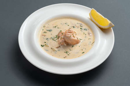finnish creamy soup with salmon fish and dill in white plate on grey backgroundの写真素材