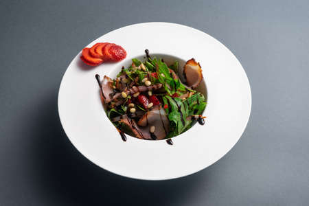 closeup of fresh salad with arugula, meat ham and strawberry on black backgroundの写真素材