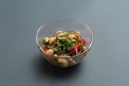 georgian lobio or salad with beans, onion, bell pepper and greens in glass bowlの写真素材