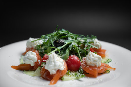 closeup of salad with salted salmon, cream cheese or arugula on black backgroundの写真素材