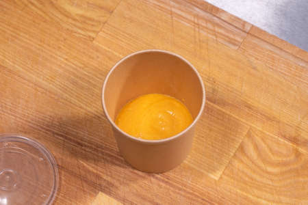 closeup of cream soup in kraft paper food container for deliveryの写真素材