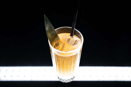 refreshing lemonade drink or cocktail with ice cube in glass on black backgroundの写真素材