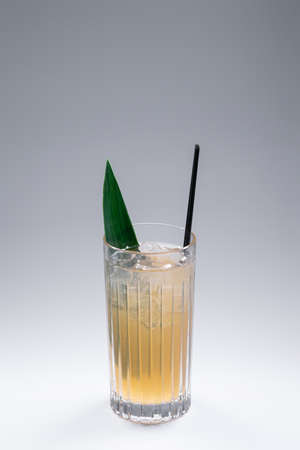 refreshing lemonade drink or cocktail with ice cube in glass on grey backgroundの写真素材
