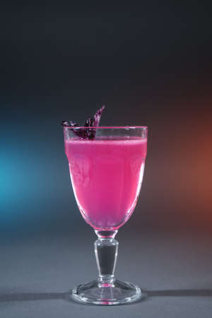 luxury alcohol pink cocktail drink with basil in glass on grey backgroundの写真素材