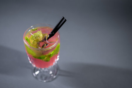 refreshing pink lemonade with mint or rose cocktail in glass on grey backgroundの写真素材