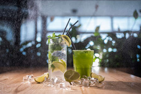 mojito with mint, lime and ice in glass and green tarkhun tarragon drink in cafeの写真素材