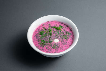cold beetroot soup with cucumber, boiled egg, dill and yogurt in white bowlの写真素材