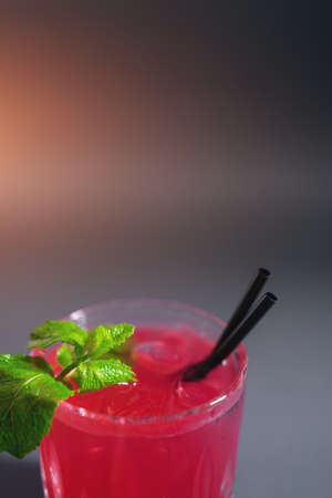 closeup of red strawberry cocktail drink with mint in glass on grey backgroundの写真素材