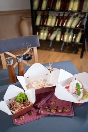 closeup of kraft paper food containers with meal on cafe table for deliveryの写真素材