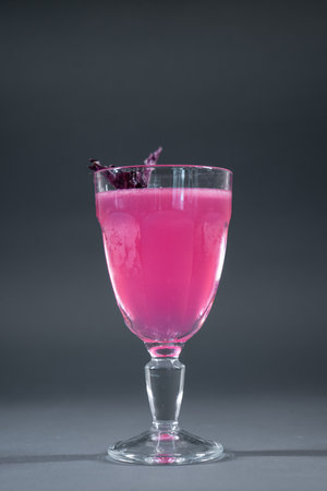 luxury alcohol pink cocktail drink with basil in glass on grey backgroundの写真素材