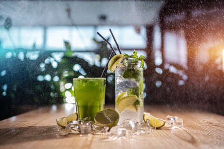 mojito with mint, lime and ice in glass and green tarkhun tarragon drink in cafeの写真素材