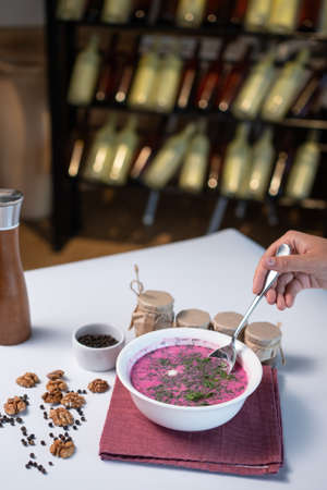 cold beetroot soup with cucumber, boiled egg, dill and yogurt in bowl on tableの写真素材