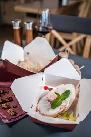 delivery food or kraft paper containers with meal or cake dessert in cafe tableの写真素材