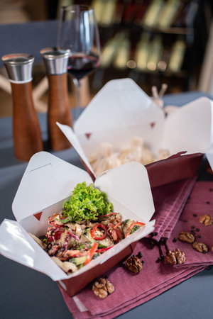 closeup of kraft paper food containers with meal or salad in cafe for deliveryの写真素材