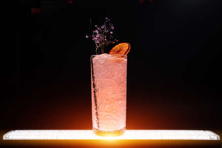 luxury lemonade drink or pink cocktail with ice in glass on black backgroundの写真素材
