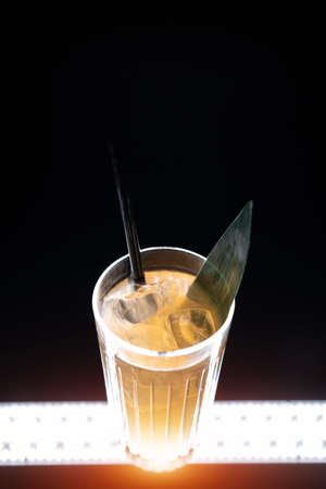 refreshing lemonade drink or cocktail with ice cube in glass on black backgroundの写真素材