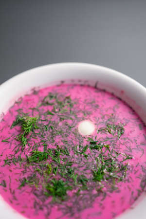 cold beetroot soup with cucumber, boiled egg, dill and yogurt in white bowlの写真素材